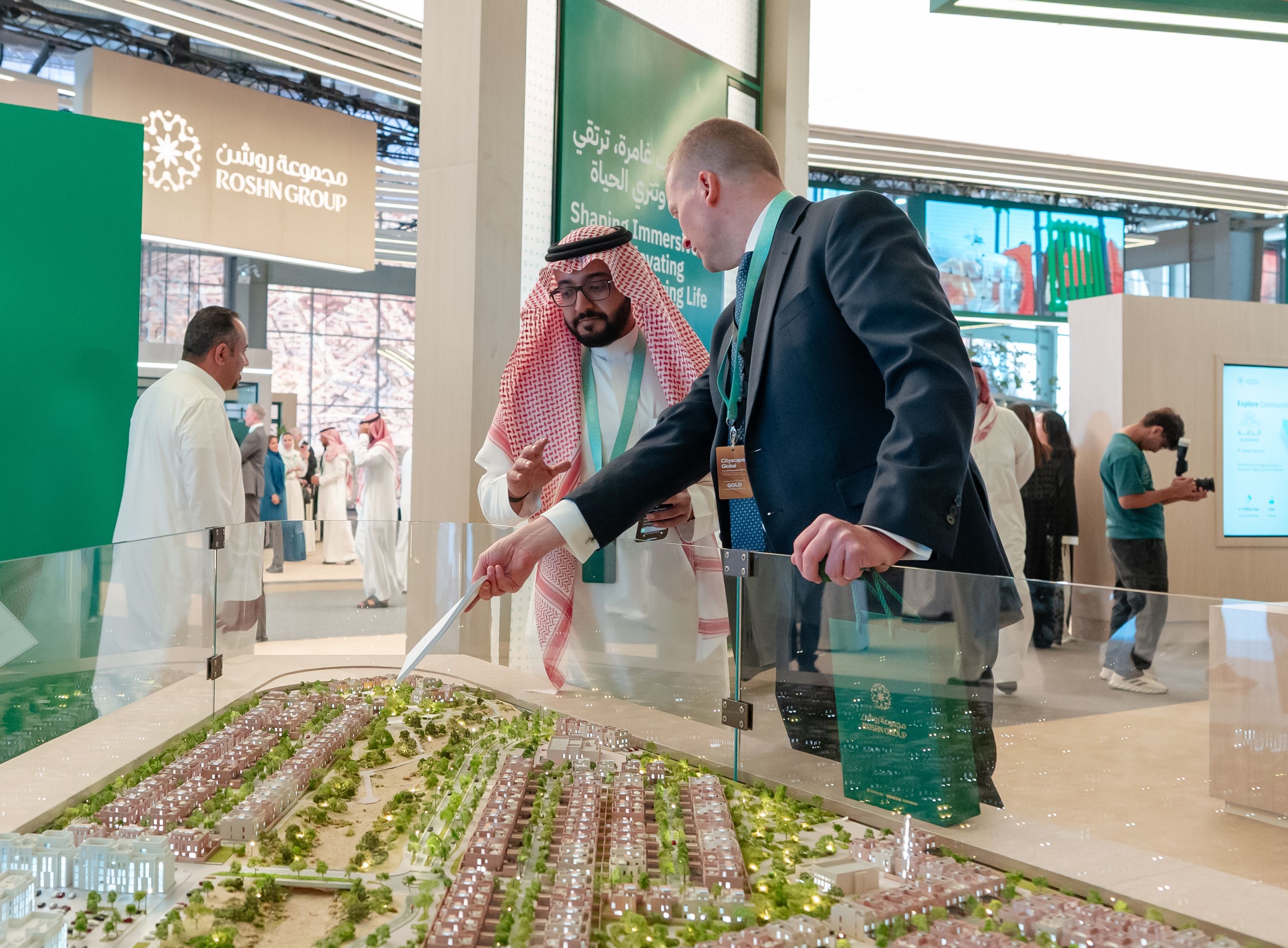 Two people engaged in a discussion about ROSHN Group projects